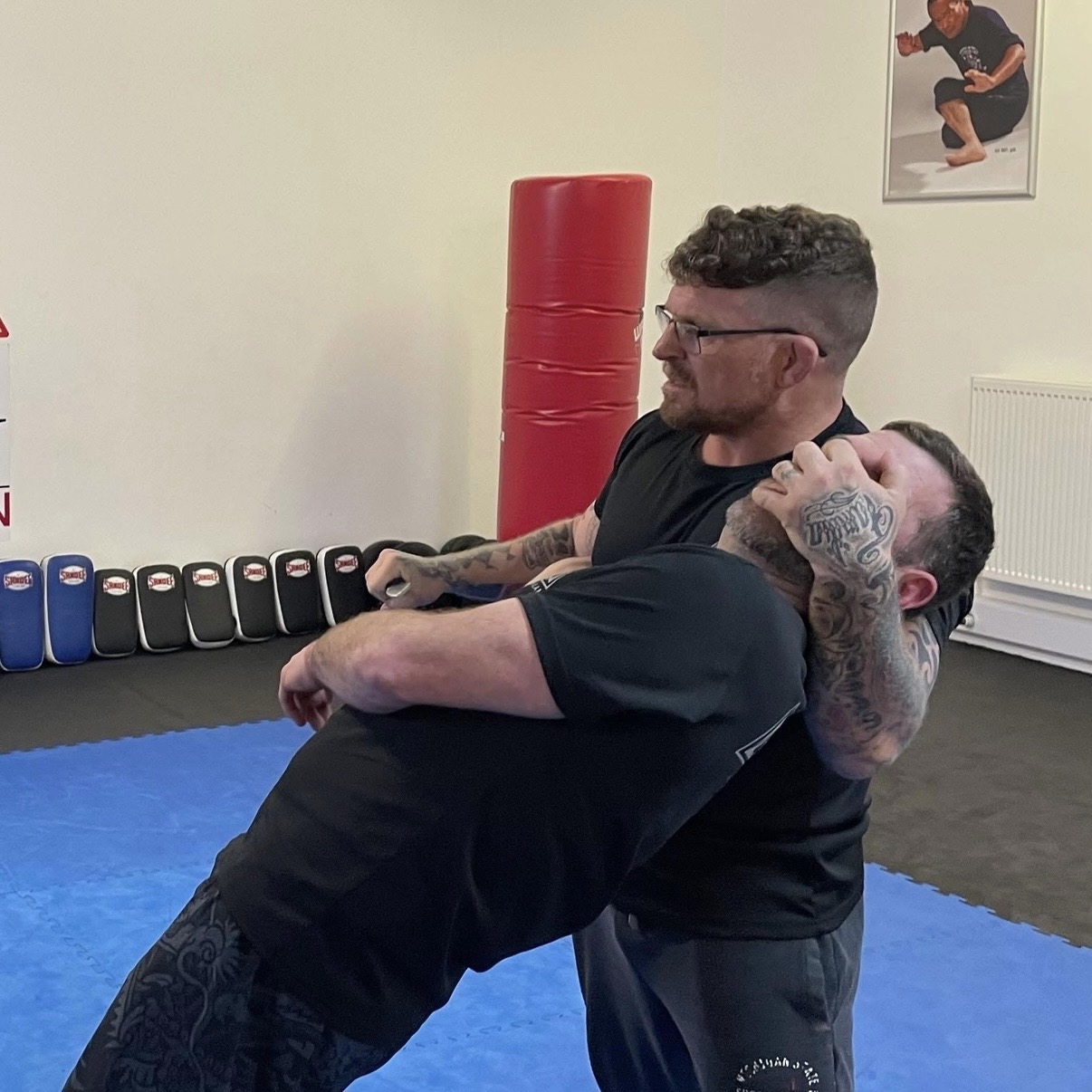 Takedown and body control drill on blue mats